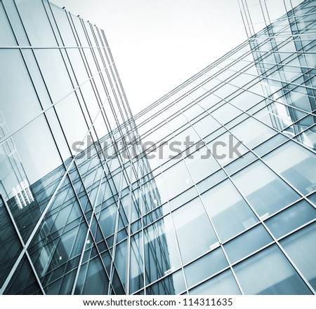 Perspective and underside angle view to textured background of contemporary glass building skyscrapers at night
