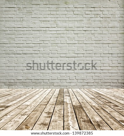 Grungy textured white brick and stone wall with wooden floor inside old neglected and deserted interior
