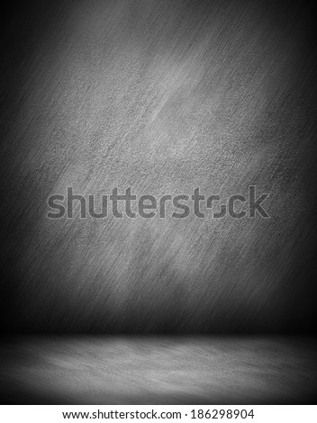 Abstract stonework background texture of an old weathered dark stucco black painted stone cement wall in rural room. Grungy cold rock surface in hard grime empty place with granite dull light floor