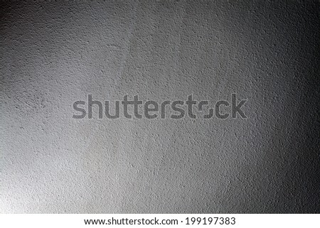Abstract stonework background texture with old weathered dark stucco black paint stone cement wall in rural room. Grungy cold rock surface in hard grime empty place with gray granite dull light floor.