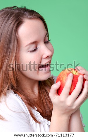 portrait of the beauty girl with red color apple in park