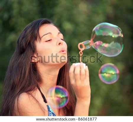 Gorgeous woman inflating soap-bubbles