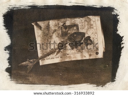 Skeleton of fish on the background of old newspapers and wooden table. Stylized background on old paper. cards and calendars.