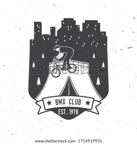 Bmx extreme sport club badge. Vector illustration. Concept for shirt, logo, print, stamp, tee with man ride on a sport bicycle. Vintage typography design with bmx cyclist and night city silhouette.