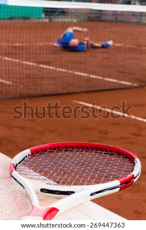 Tennis player lost the game and rolls on the clay court