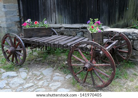 Old cart and flowers in the wooden flower boxes in Bulgaria