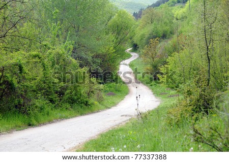 Long winding dirt road in the Balkan Mountains in Bulgaria in the spring.