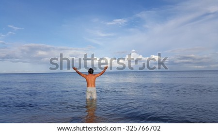 Man lift his hand up to reach the sky in the sea