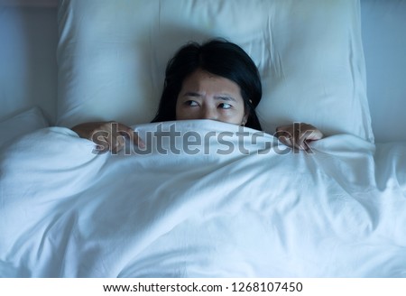 Nightmare or bad dream,Asian woman with scare and panic while lying down under the blanket in bedroom Stock fotó © 