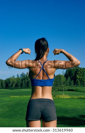 European girl with the athletic muscle in the evening on the lawn