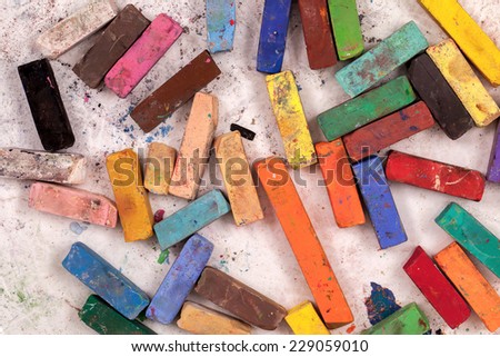 Used colorful Pastel art sticks viewed from above on a white background