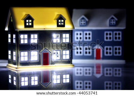Two houses at night, one has lights on