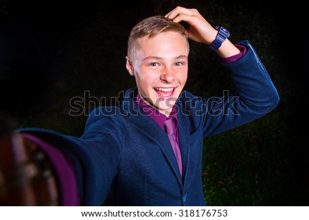 Just me and no one else. Top view of handsome young man making selfie and smiling while standing against black background