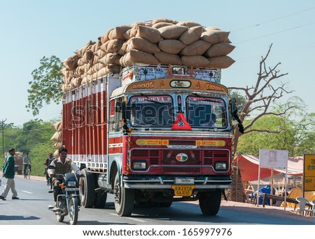 NAGAUR, INDIA - CIRCA FEBRUARY 2011: Overloaded dump truck filled with jute bags on the road.