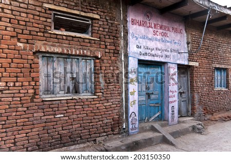 KHAJURAHO, INDIA - CIRCA FEBRUARY 2011: Entrance to small village public school in rural India. The name and location of the school with its license number is painted above the door.