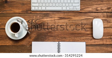 Working Place on Natural Rough Wooden Desk From Above View with Keyboard Computer Mouse Coffee Mug Notepad