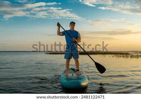 Similar – Image, Stock Photo Woman floating on paddleboard in lake