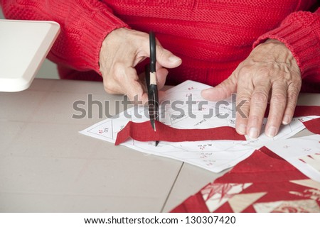 Quilter cuts fabric to fit pattern