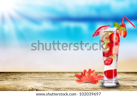 Fresh summer cocktail on wooden table. Blur beach on background