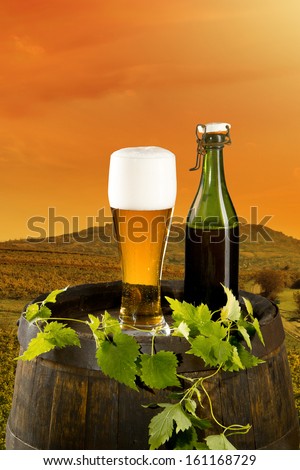 Beer keg with glass of beer on rural countryside background
