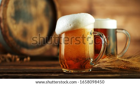 Overflowing foam head from beer glass pint, placed on wood