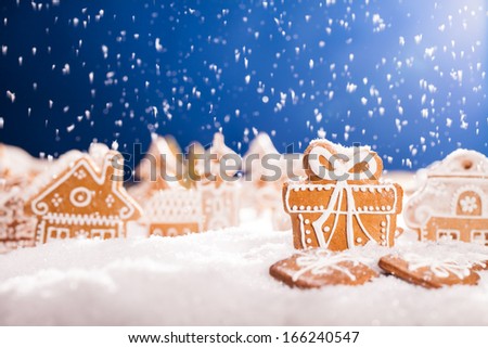 Macro photo of gingerbread village with falling snow