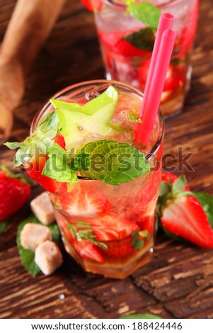Fresh summer strawberry mojito drink with ice, served on black stone