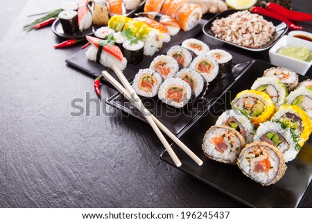 Various kinds of sushi food served on black stone