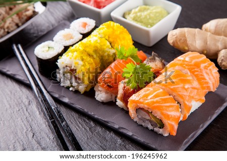 Various kinds of sushi food served on black stone