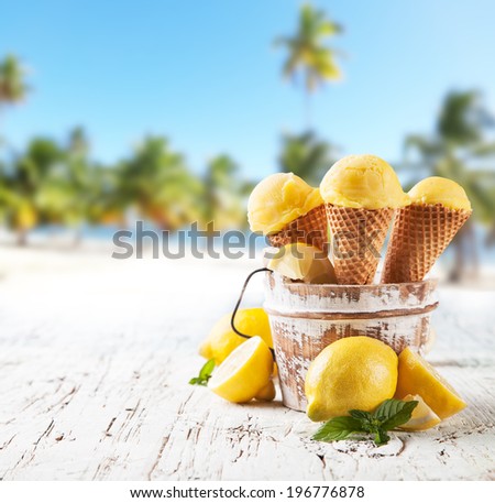 Fresh fruit ice cream scoops in cones, blur beach on background