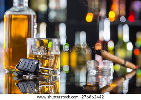 Whiskey drink with smoking cigar and car key on bar counter. Concept of alcohol danger and car driving