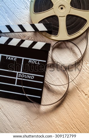 Film camera chalkboard and roll on wooden table