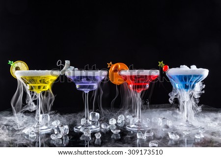 Martini drinks with dry ice smoke effect, served on bar counter with dark colored background