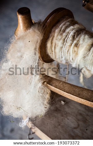 White wool and yarn on old fashioned spinning wheel