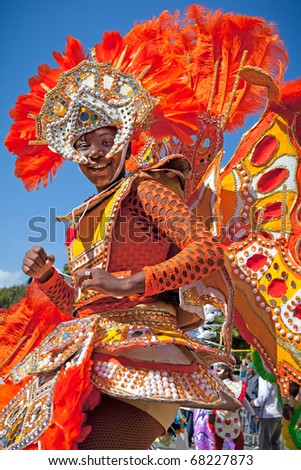 NASSAU, THE BAHAMAS - JANUARY 1 - Female troop leader dressed in bright orange feathers, dances in Junkanoo, a traditional island cultural festival on Jan 1, 2011 in Nassau