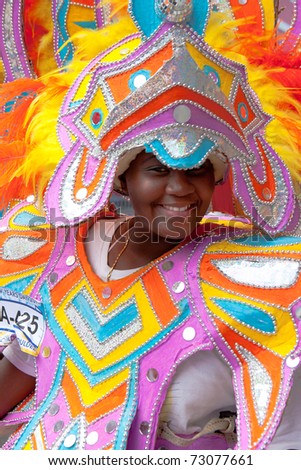 NASSAU, THE BAHAMAS - JANUARY 1 - Smiling, dancing woman in pink and orange costume, performs in Junkanoo, a traditional island cultural festival in Nassau, Jan 1, 2011