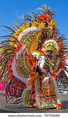 NASSAU, THE BAHAMAS - JANUARY 1 - Dancing man in yellow and orange feathered costume, performs in Junkanoo, a traditional island cultural festival in Nassau, Jan 1, 2011