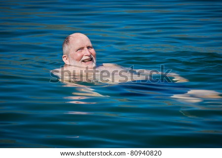 Senior man swims in Dalyan River near the Mediterranean in Turkey