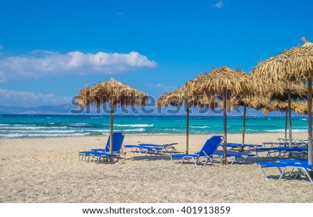 Chrisi (Chrysi) island beach background with straw sunshades, Crete, Greece. One of the most beautiful uninhabited island of Greece.