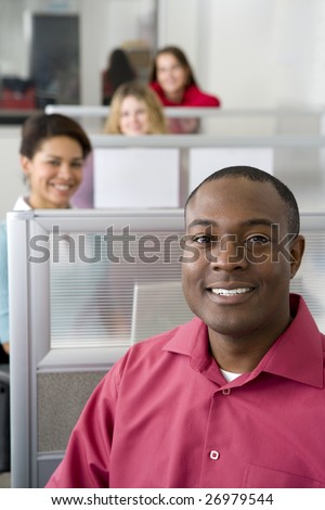 Businessman and co-workers sitting in cubicles