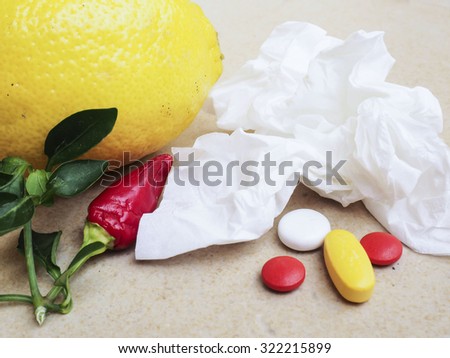 handkerchief and pills on table close-up, natural remedies, lemon and peppers