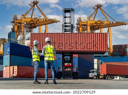 Engineers are overseeing the transportation of cargo with containers inside the warehouse. Container in export and import business and logistics. ストックフォト © 