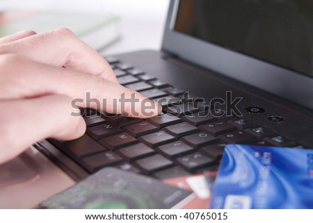 The hand works with the keyboard, in the foreground credit cards. Small depth of sharpness.