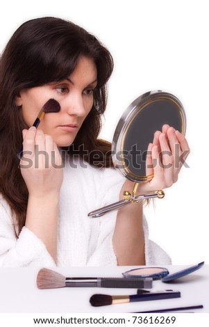 Pretty young brunette woman putting on her makeup; one of series of this model in portfolio