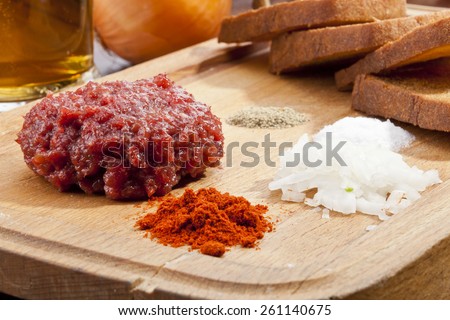 Steak tartar with the fried bread on the wooden trencher