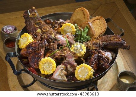 Various kind of grilled meat arranged on wooden plate