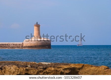 The lighthouse on the end of the Grand Harbor Breakwater seen from the opposite shore on a clear bright day.