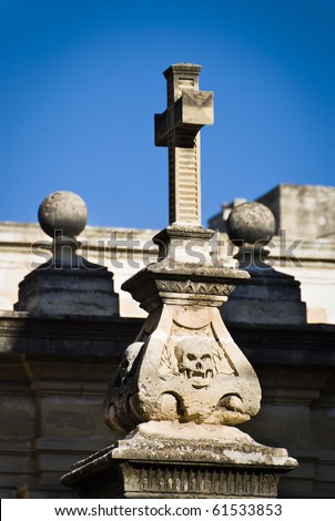 A stone cross erected on a base adorned with skulls found in the courtyard of St John\'s Co-Cathedral - built by the Knights of St John, Valletta, Malta.