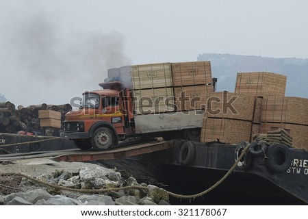 Tawau Sabah Malaysia - September 16, 2015 : Truck driver bring piles of timber product onto barge at Tawau port. This port is one of the international hub for timber export from Sabah Borneo.