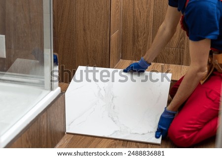 Foto Bild Handwerker beim Verlegen von Fliesen auf einer Terrasse